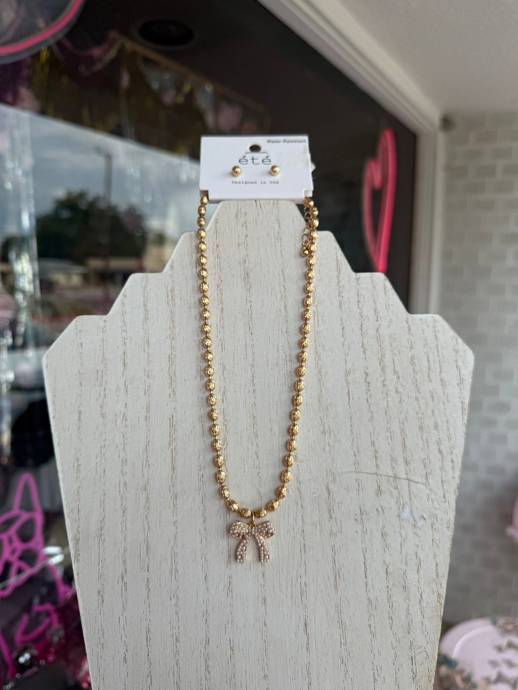 Gold pearl bow necklace